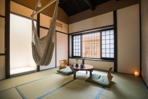 a room with a hammock and a table and two windows at Kyomachi Hoshizuki in Kyoto +31 photos