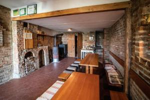 a restaurant with wooden tables and a brick wall at Vinný Sklep U Terezy a Jakuba in Moravská Nová Ves