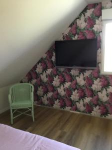 a bedroom with a tv and a chair at La Malvrais in Janzé