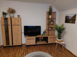 una sala de estar con TV en un centro de entretenimiento de madera en Ferienwohnung Pucher - Altaussee en Altaussee