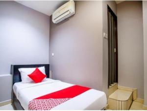 a bedroom with a bed with a red pillow at HOTEL AVATARR in Batu Caves