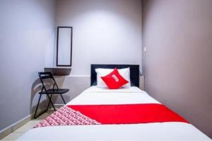 almohada roja en una cama en una habitación en HOTEL AVATARR en Batu Caves