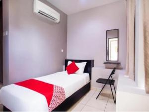 um quarto com uma cama vermelha e branca e um espelho em HOTEL AVATARR em Batu Caves
