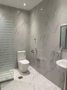 een witte badkamer met een toilet en een wastafel bij فندق ارجان بارك Arjan Park Hotel in Wadi ad-Dawasir