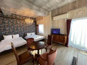 een slaapkamer met 2 bedden en een tafel en een televisie bij WOLF PACK apartment 1002 in Osaka