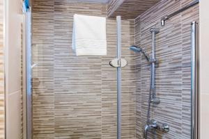 baño con ducha y puerta de cristal en Apartment Triana en Sevilla