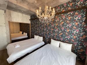 een slaapkamer met 2 bedden en een kroonluchter bij WOLF PACK apartment 1002 in Osaka