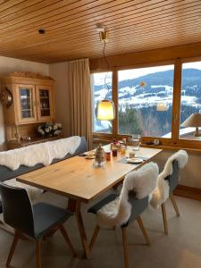 a dining room table with chairs and a large window at Hoch über dem Rheintal in Breil/Brigels