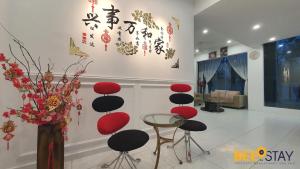 a lobby with red and black chairs and a vase of flowers at Cheng Landed Villa in Taman Bertam Setia Melaka in Malacca