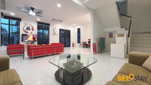 a living room with a red couch and a glass table at Cheng Landed Villa in Taman Bertam Setia Melaka in Malacca