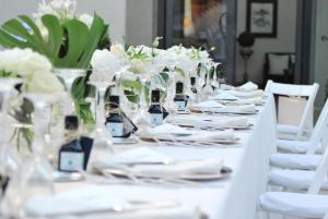 a long table with white plates and wine glasses at Villa Il Sasso - Dimora d'Epoca in Bagno a Ripoli