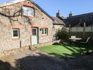 a stone house with a table in the yard at The Granary in Knelston