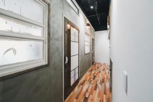 a hallway with a wooden floor and a window at コトリ コワーキング&ホステル高松 in Takamatsu