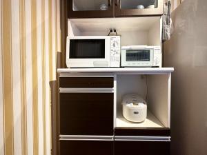 La cuisine est équipée de 2 fours micro-ondes et d'un four micro-ondes. dans l'établissement guest house Kuu - Vacation STAY 46399v, à Takashima