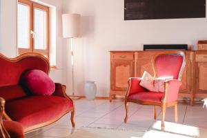 a living room with two chairs and a dresser at 4-Zimmer-Ferienwohnung Waldblümle in Dobel