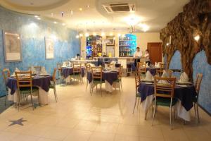 a restaurant with tables and chairs in a room at Chernomor Hotel in Shirokaya Balka