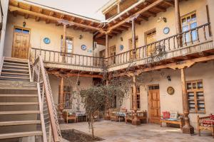 a building with wooden balconies and tables and chairs at Salom Inn in Bukhara