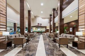 a lobby with couches and chairs in a building at Holiday Inn Riyadh Al Qasr, an IHG Hotel in Riyadh