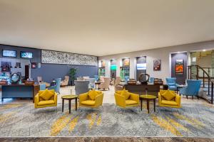 una sala de espera con sillas y mesas amarillas en Holiday Inn Riyadh Al Qasr, an IHG Hotel en Riad