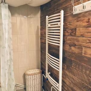 a bathroom with a wooden wall with a towel rack at Tóparti Kuckó in Mályi