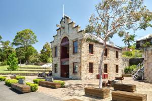 un edificio in pietra con un albero di fronte di Retreat on Darling - Harbour Views 3 Bed a Sydney