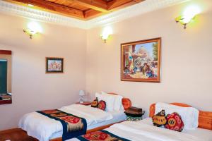 a room with two beds and a painting on the wall at Salom Inn in Bukhara