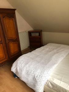 1 dormitorio con 1 cama y armario de madera en logement complet 2 chambres garage wifi de 1 a 5 voyageurs, en Montfort-le-Gesnois