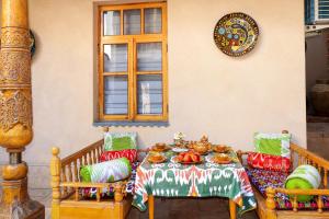 una mesa y sillas con un plato de comida. en Salom Inn, en Bukhara