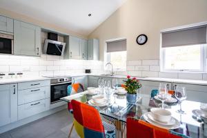 una cocina con una mesa de cristal con sillas coloridas en Fantastic and Sleek 3BD Home Wrington Bristol, en Bristol