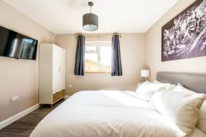 Un dormitorio con una gran cama blanca y una ventana en Fantastic and Sleek 3BD Home Wrington Bristol, en Bristol