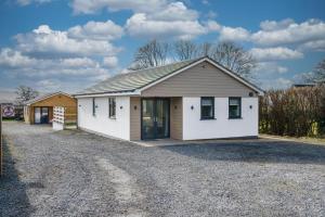a small white house with a gravel driveway at Fantastic and Sleek 3BD Home Wrington Bristol in Bristol