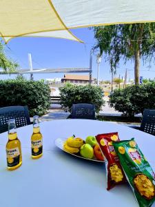 una mesa con un plato de comida y dos botellas de cerveza en Ayia Anna Apartment, en Ayia Napa