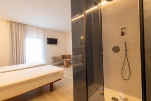 a bathroom with a shower and a bed in a room at Play Hotel Ibiza - Adults Only in Ibiza Town