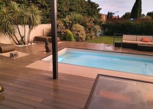 a swimming pool in a yard with a patio at Maison de vacances contemporaine avec piscine in Vedène