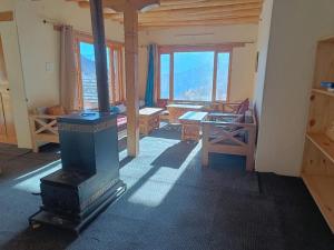 a room with a stove and a table and windows at Ulley Lodge in Saspul Gömpa