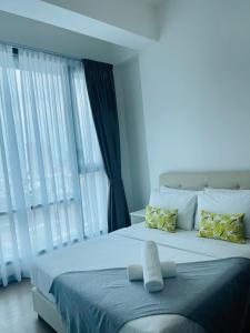 um quarto com uma grande cama branca com almofadas amarelas em Opus Residences Kuala Lumpur by Luna em Kuala Lumpur