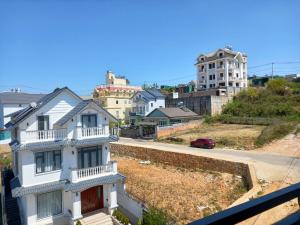 uma vista a partir de uma varanda de uma casa branca em KP Villa Dalat em Da Lat