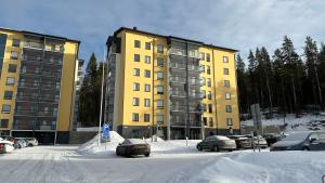 a parking lot with cars parked in front of buildings at Huhta Sport in Jyväskylä