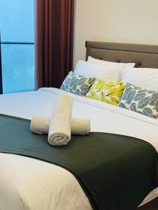 duas camas com toalhas em cima em Opus Residences Kuala Lumpur by Luna em Kuala Lumpur