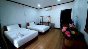 pokój z dwoma łóżkami i kwiatami w obiekcie Vang Vieng Eco Lodge w mieście Vang Vieng