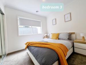 ein Schlafzimmer mit einem Bett mit einer orangefarbenen Decke in der Unterkunft Minta Estate Berwick 4 bedroom house, no sharing in Stadtteil Berwick