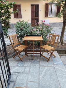 drewniany stół i dwa krzesła obok stołu w obiekcie Ca' Letizia w mieście Stresa