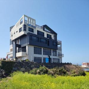 een hoog gebouw bovenop een stenen muur bij Eutteum-won Pension in Jeju-stad