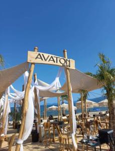 een bord op een strand met stoelen en parasols bij Avaton Luxury Resort and Spa Access the Enigma - Adults Only & Kids 14 Plus- in Asprovalta