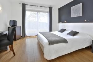 een slaapkamer met een bed, een bureau en een raam bij Hôtel Le Mas del Pechs in Sarlat-la-Canéda