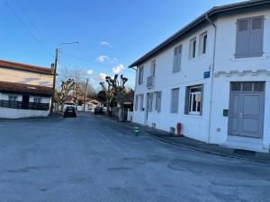 an empty street next to a white building at La Chouette du lac Marion in Biarritz
