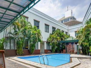 a swimming pool in front of a building at Grand Cikarang Hotel in Tegalgede