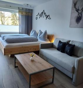 a living room with a couch and a coffee table at Ferienwohnung AllgOy in Oy-Mittelberg