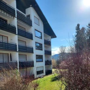 a white building with black balconies on the side of it at Ferienwohnung AllgOy in Oy-Mittelberg