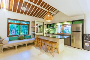 an open kitchen with a couch and a kitchen island at Villa Senan in Seminyak